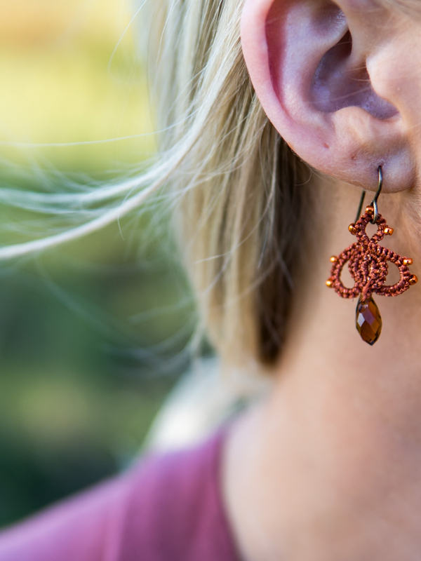 Close-up of Bloomdrop earings with orange crystal