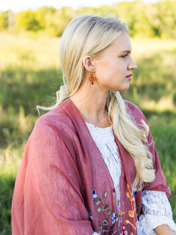 Model portrait wearing hand-tatted Bloomdrop earrings outdoors.