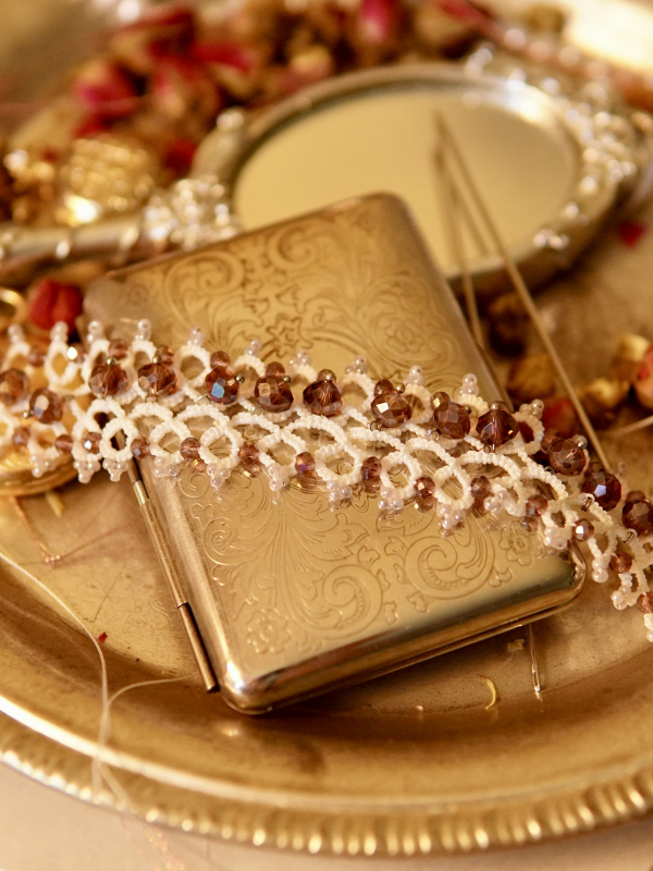 White tatted lace bracelet with dangling lavender cystals on silver clasp