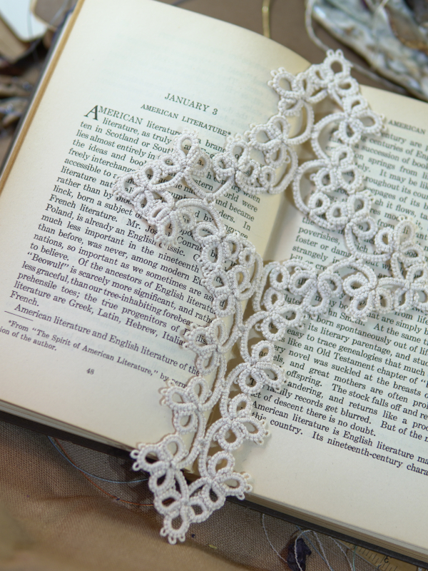 Winter White Cross Bookmark Elegant white tatted lace cross bookmark laid across an open book