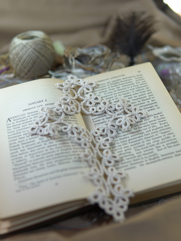 Winter White Cross Bookmark Ivory-white tatted lace cross bookmark displayed on vintage book pages