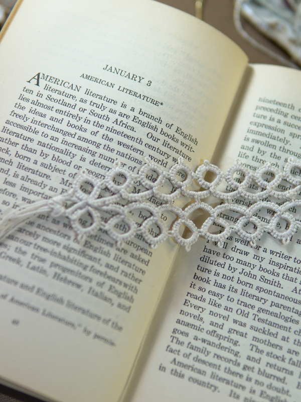 Ivory Whisper Bookmark Ivory tatted lace bookmark lying on an open book with soft background props