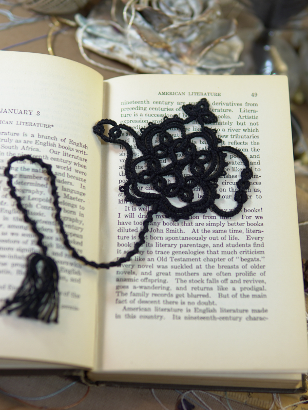 Teapot Lace Bookmark – Black Handmade black lace teapot bookmark displayed across open vintage book