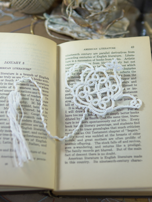 Teapot Lace Bookmark – White White tatted lace teapot bookmark resting on the pages of an open book