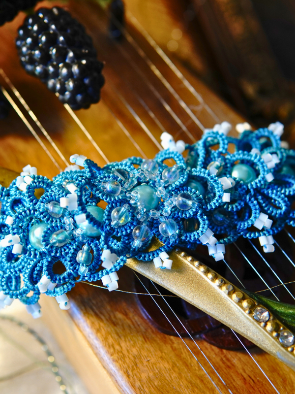 Aqua Ankars braceelt with pearls styled on wooden instrument.