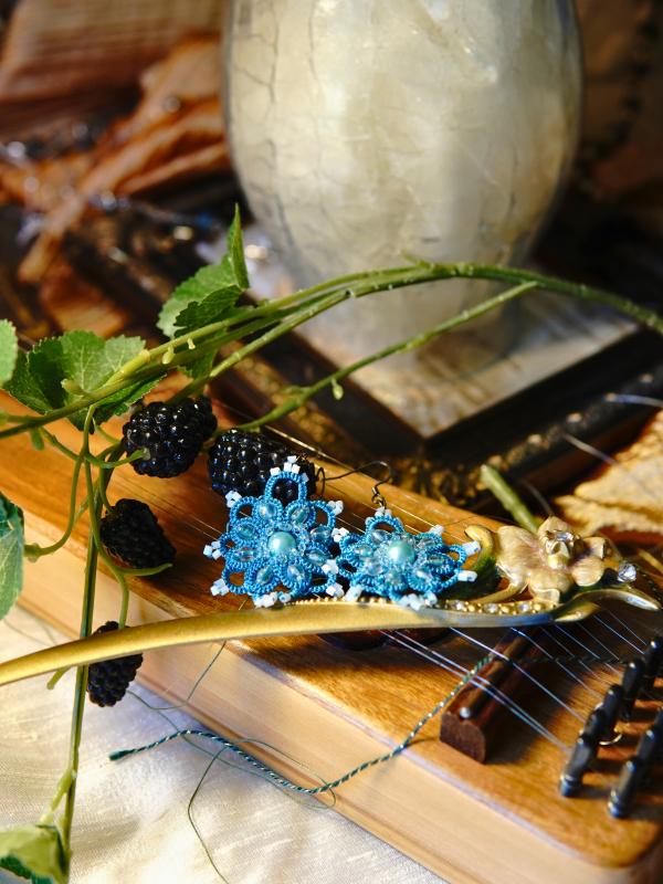 Duchess Drops aqua Ankars earrings with pearls Duchess Drops earrings styled on wooden instrument.