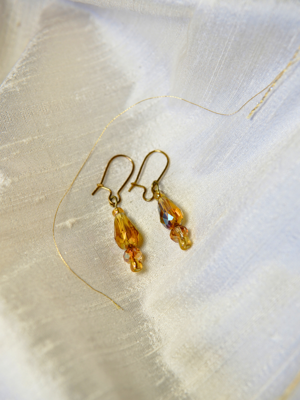 Earrings in warm ember tones. Close-up of bead earrings that complement The Gilded Emberleaf necklace.