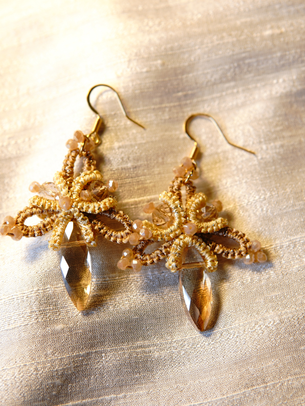 Handmade champagne lace earrings on cream fabric