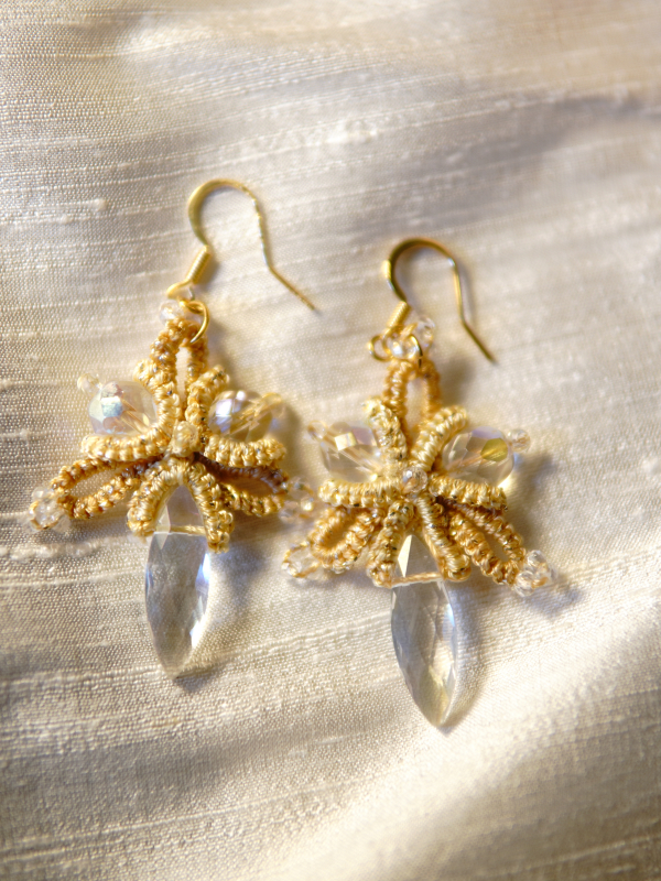 Sunstar golden tatted lace earrings with crystal drops Handmade gold earrings shown on cream fabric