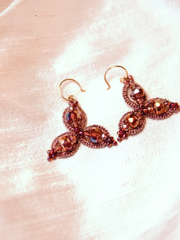 Pink and gold crystal earrings displayed in soft evening light.