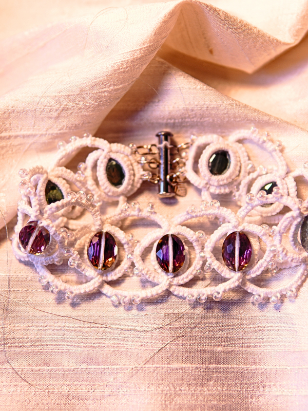 Whisperbind Bracelet – White Tatted Lace with Aurora Borealis Crystals Whisperbind bracelet displayed on silk