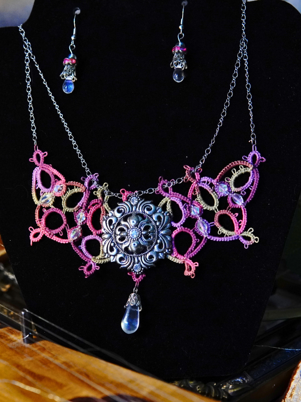 Raspberry Rain tatted necklace with silver sigil and crystal drop Raspberry Rain necklace and earrings displayed on a black jewelry bust