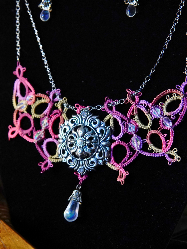 Raspberry Rain tatted necklace with silver sigil and crystal drop Necklace and matching earrings set shown against dark velvet backdrop