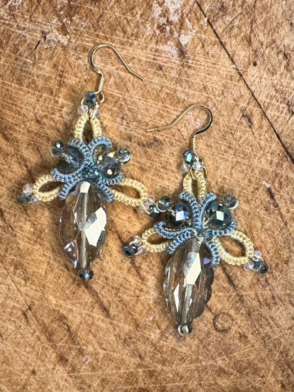 Bright sky-inspired lace earrings from Aeluin Yellow blue lace earrings displayed on wood