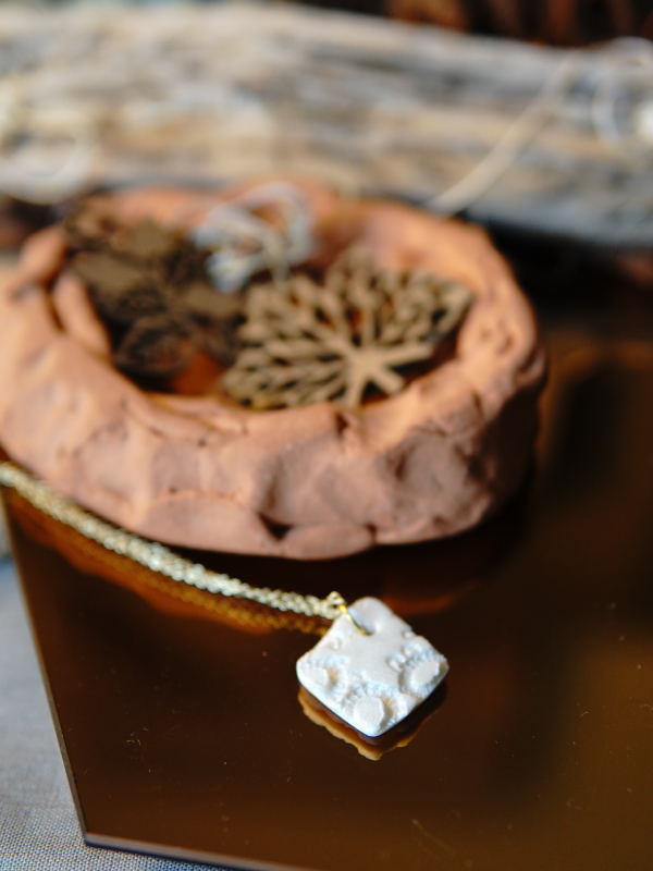 Ivory clay diamond pendant on gold chain. Lace impression necklace on gold chain