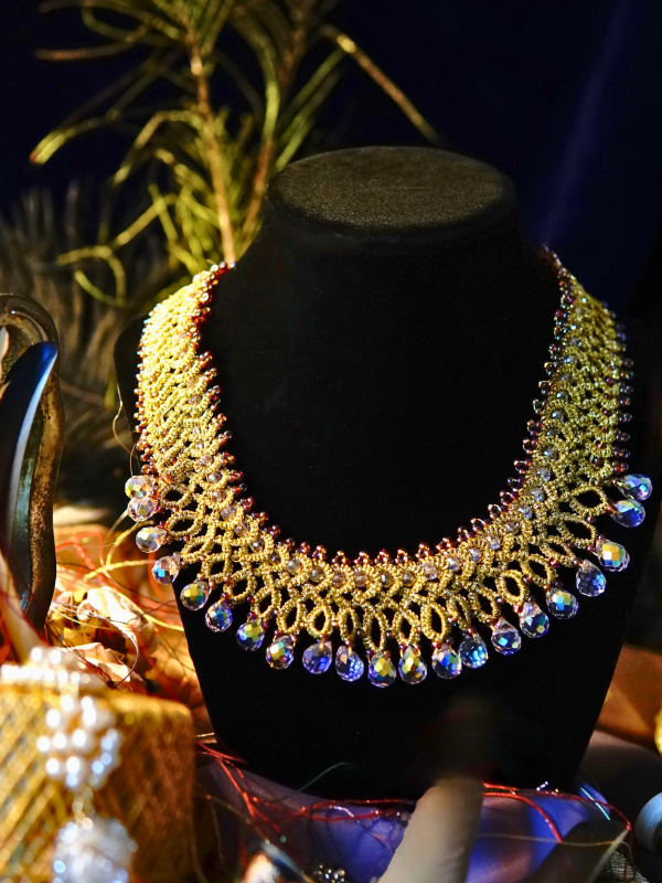 Jewel of Intrigue gold lace necklace and earrings with iridescent beads Jewel of Intrigue gold lace collar shown against a dark velvet display