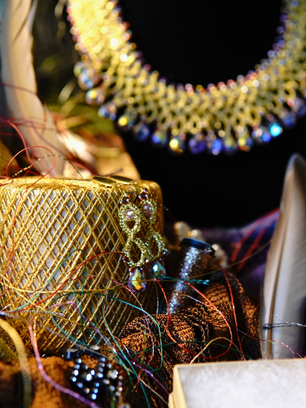 Jewel of Intrigue gold lace necklace and earrings with iridescent beads Iridescent lace earrings displayed on textured gold thread for detail