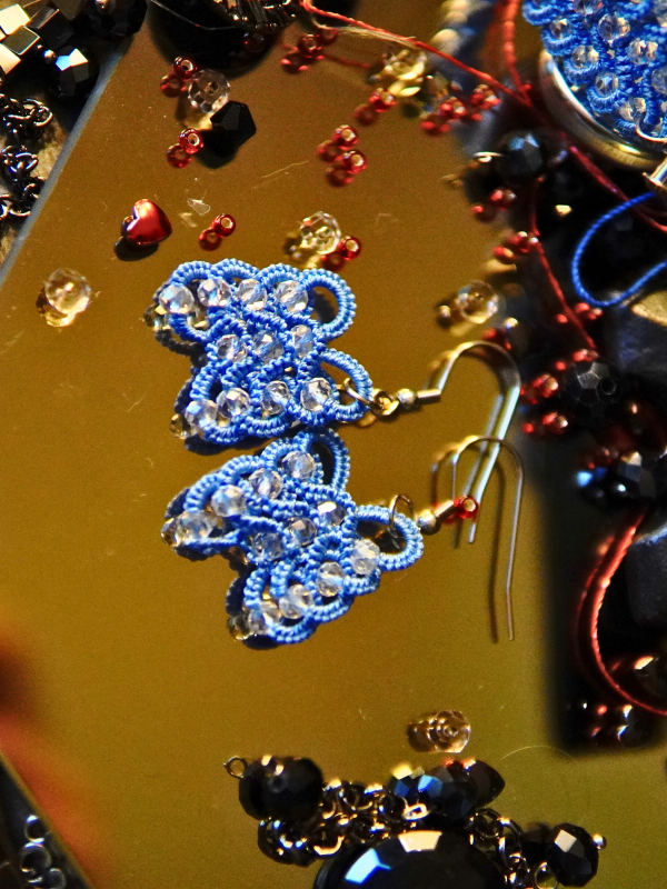 Frostwarden earrings in icy blue thread Close-up of blue lace and crystal beads
