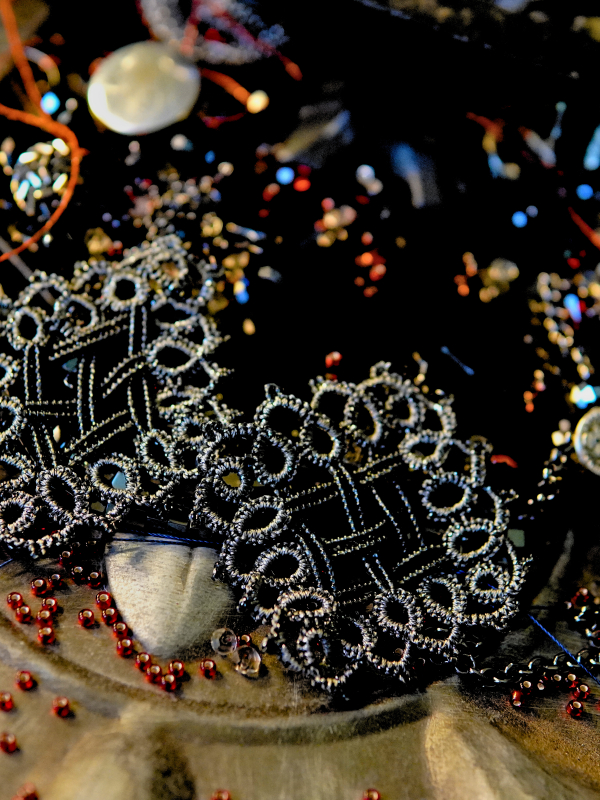 Ironlace chainmail-pattern tatted earrings - metallic black lace and beads Ironlace earrings displayed on dark props