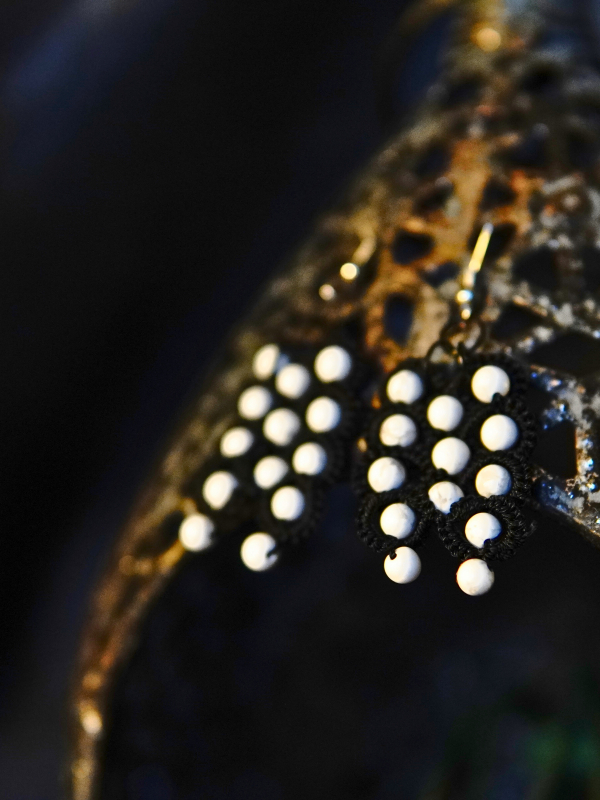 Oathforged shadow-themed earrings Earrings made of black thread and howlite beads displayed on Oathforged backdrop