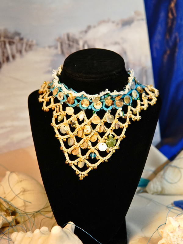 Sandy Treasures necklace in gold, blue, white with shells, pearls, glass.