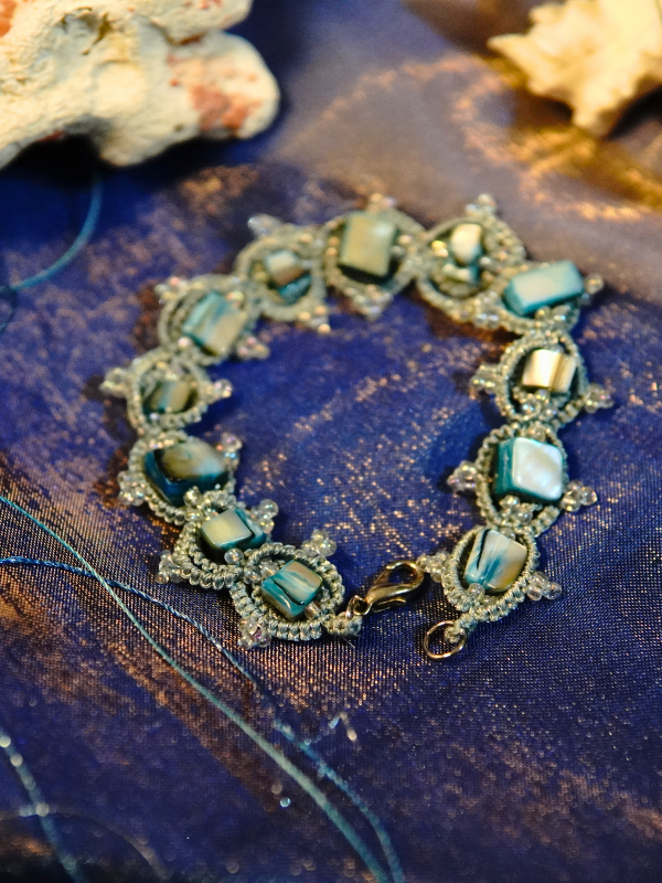 Ocean-inspired tatted lace bracelet w/ seashell and aurora borealis seed beads.