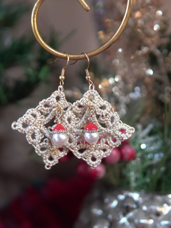 Handmade tatted lace earrings with Santa-themed bead accents displayed on a holi