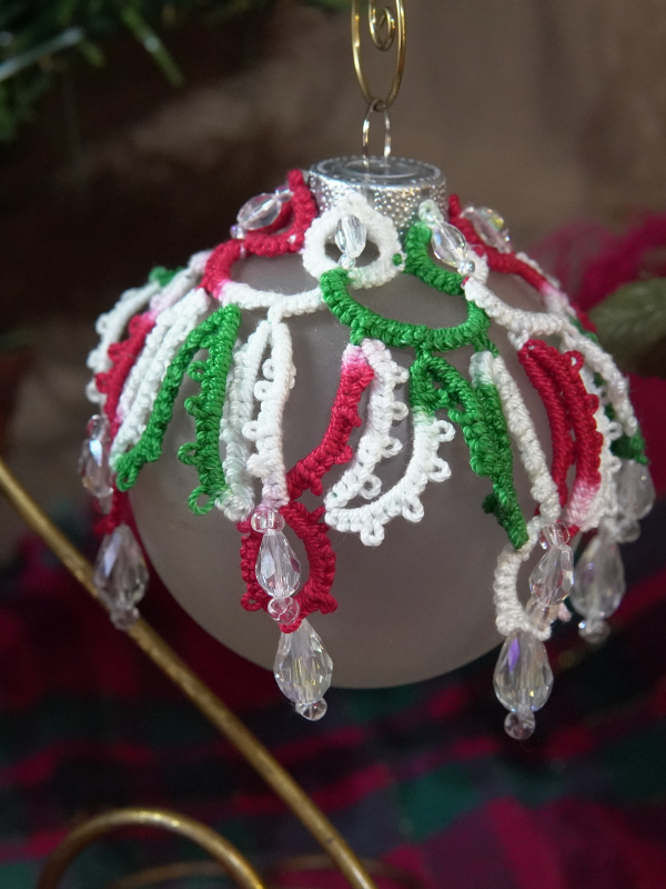 Hand-tatted Christmas lace bauble in festive colors