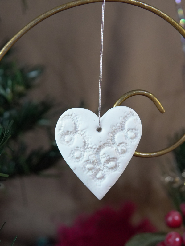 Heart: Lace-imprinted pearlescent heart ornament hanging on tree
