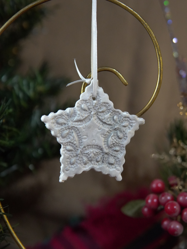 Silver star ornament with embossed tatted-lace pattern