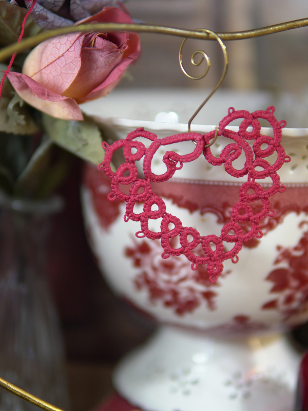 Handmade red lace heart displayed among vintage props.