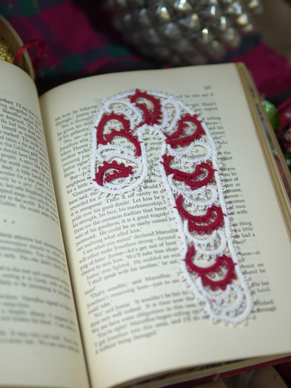 Holiday candy cane bookmark tatted in red and white thread displayed across book