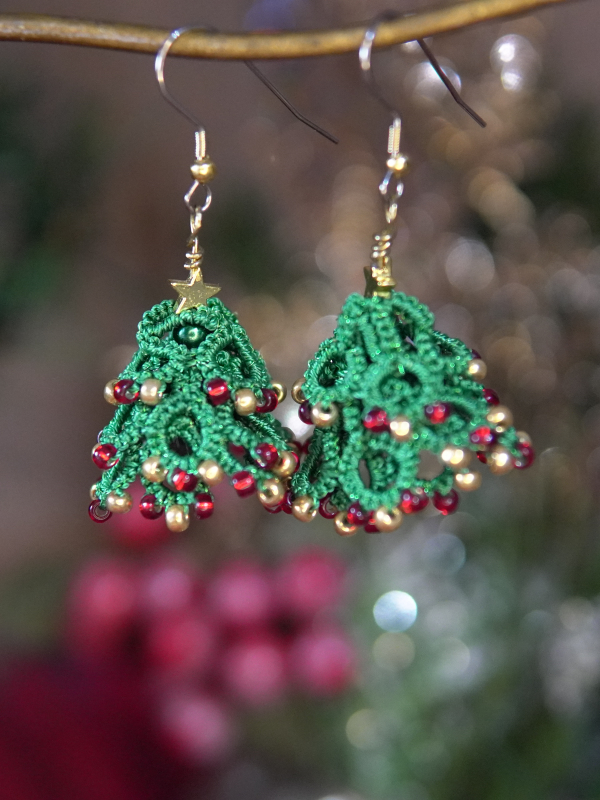 Lace Christmas tree earrings with red and gold beads hanging on hook