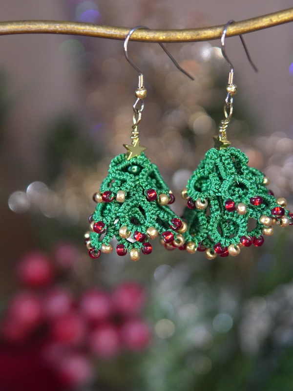 3D tatted green Christmas tree earrings with gold accents on display