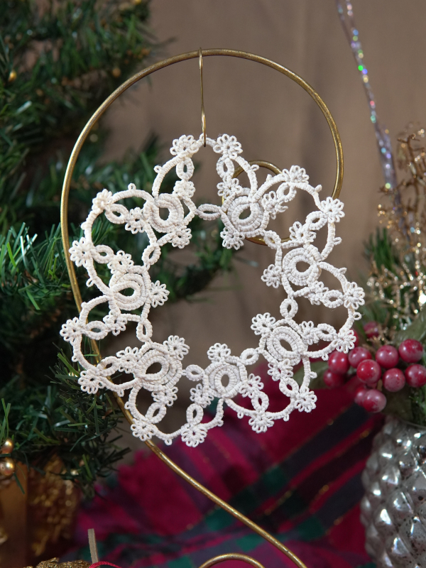 Handmade winter decor Intricate lace snowflake ornament displayed with holiday greenery