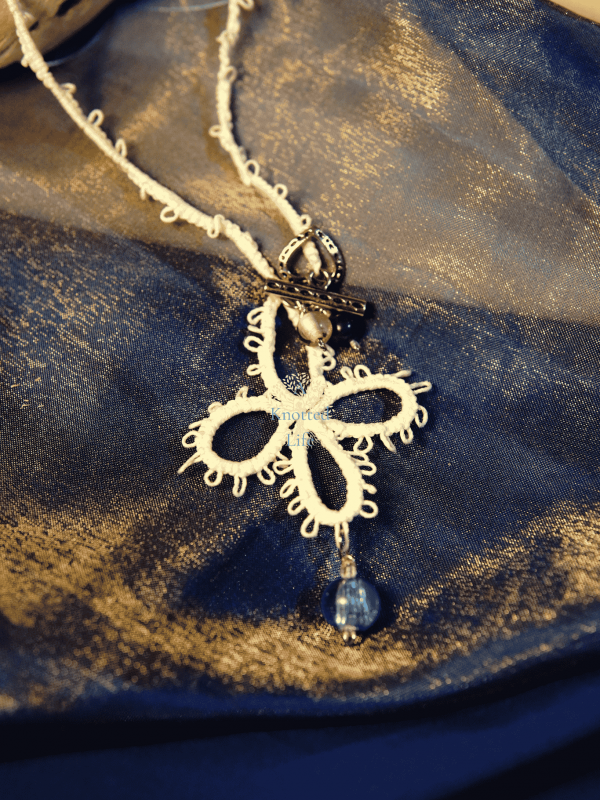 Tidecross Blessing - A Knotted Life Tatted Jewelry tidecross lace necklace with ocean blue glass bead centerpiece.