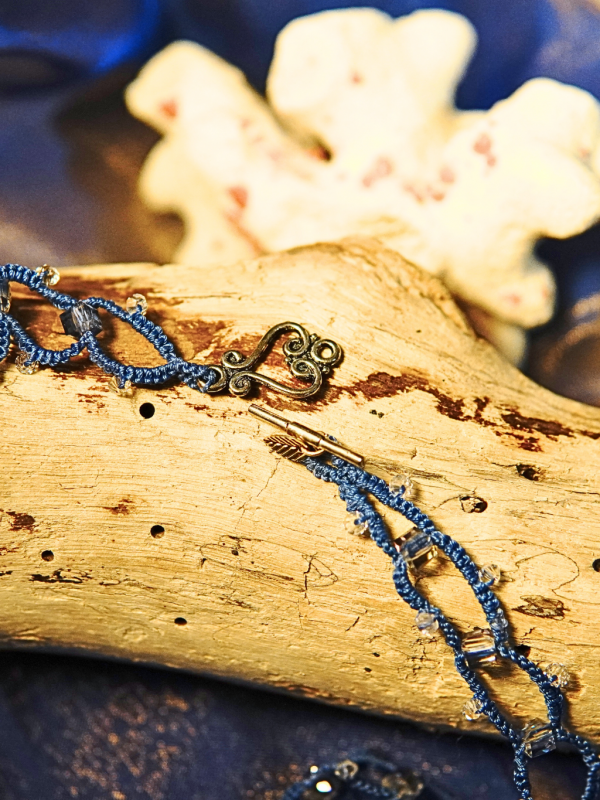 Blue lace choker with glinting beads and toggle clasp.