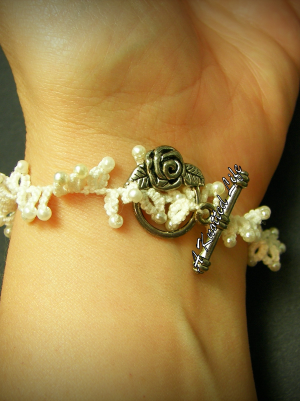 Rose & Ruffle Tatted lace bracelet closes with a rose toggle clasp. White tatted lace bracelet shown on a wrist closes with toggle clasp