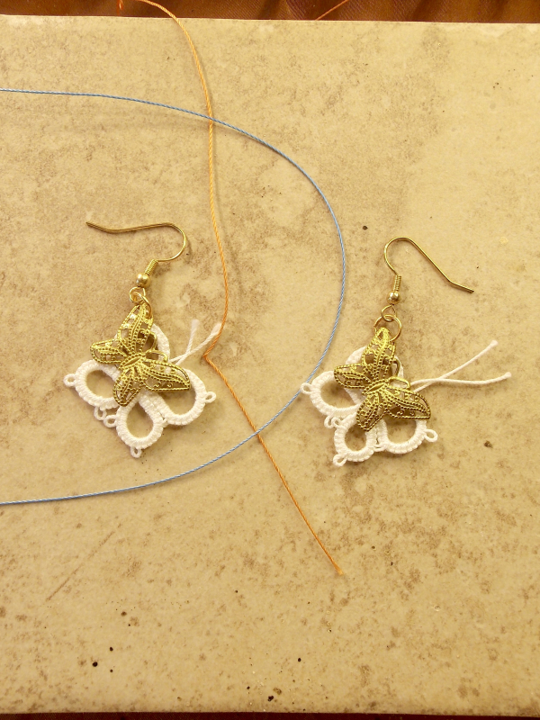 Twicewing earrings featuring brass butterflies and lace thread.