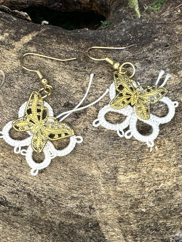 Twicewing earrings showing brass butterflies with tatted loops.