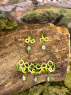 Green tatted jewelry set displayed on moss and wood