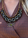 Brown lace necklace featuring green stones and crystal shimmer