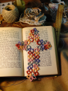 A bright multicolor tatted lace cross bookmark in sunrise hues