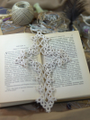 Classic white tatted lace cross bookmark photographed on an open book