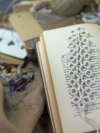 Handmade white lace bookmark displayed across open vintage book pages