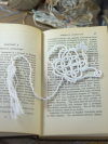 White tatted lace teapot bookmark resting on the pages of an open book