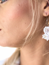 Model wearing Tatted white earrings reflecting soft riverlight