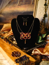 Necklace set shown on black display with warm lighting