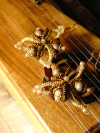 Brown and cream tatted earrings with gold beads on instrument