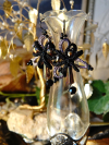 Obsidian Bloom earrings displayed on glass vase